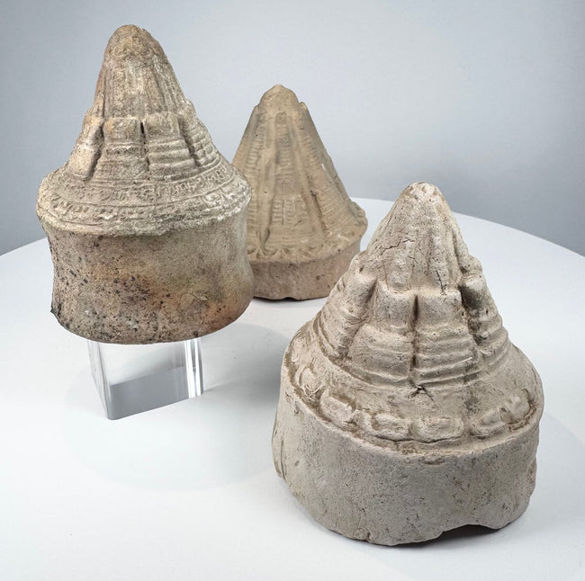 Ancient terracotta Buddhist stupas displaying varied conical forms and intricate architectural detailing