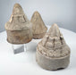 Ancient terracotta Buddhist stupas displaying varied conical forms and intricate architectural detailing