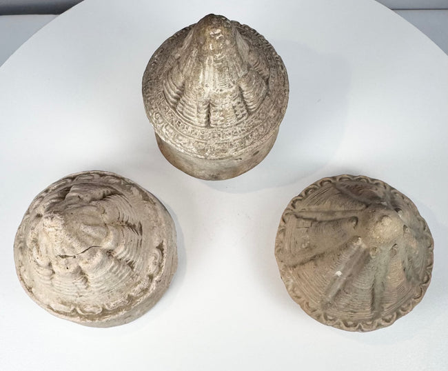 Collection of miniature Buddhist reliquary stupas in grey, buff, and cream-toned terracotta