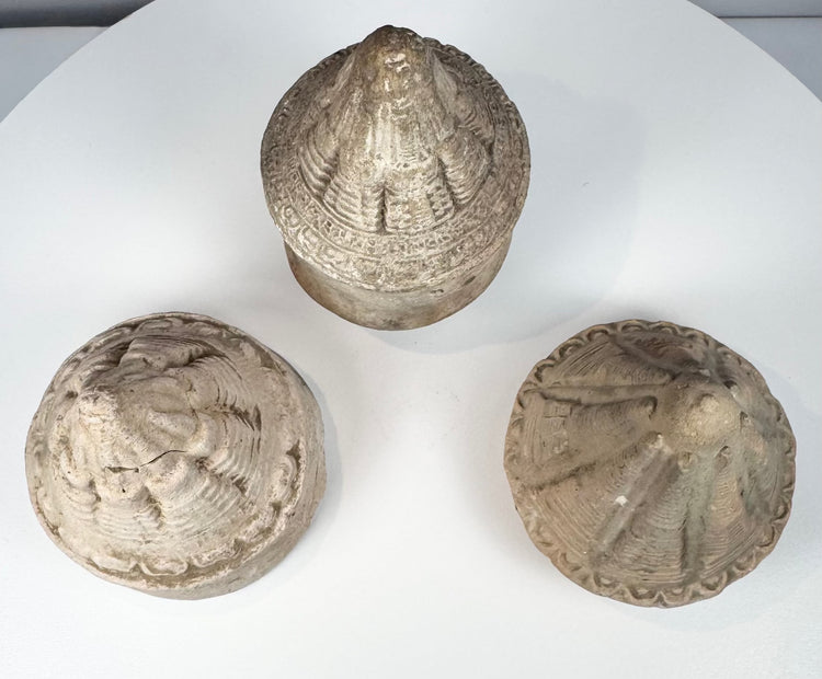 Collection of miniature Buddhist reliquary stupas in grey, buff, and cream-toned terracotta