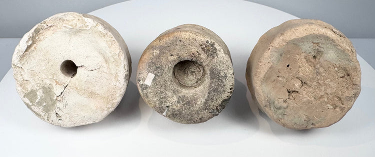 Bottom view of three Eastern Indian Buddhist terracotta votive stupas showing base cavities and impressed features