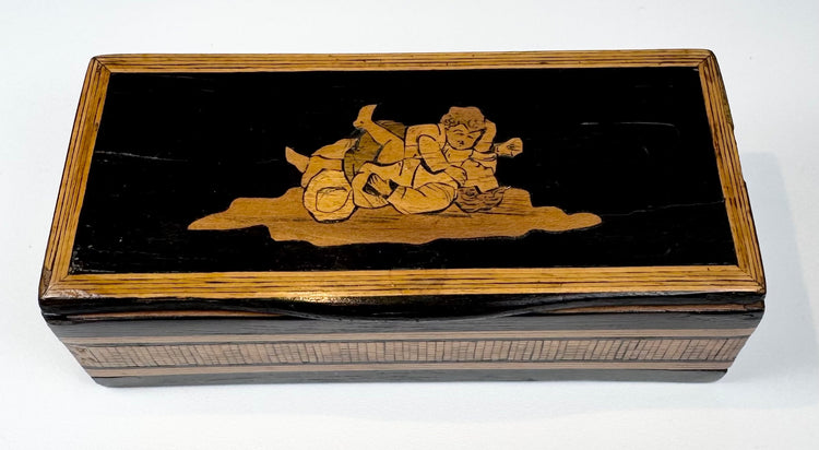 Top view of Anglo-Indian marquetry box showing reclining figural wood inlay and decorative borders