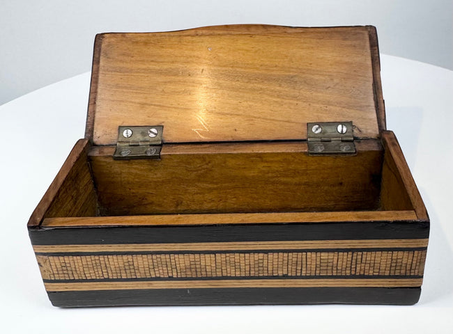 Open Anglo-Indian marquetry box showing natural wood interior and brass hinges