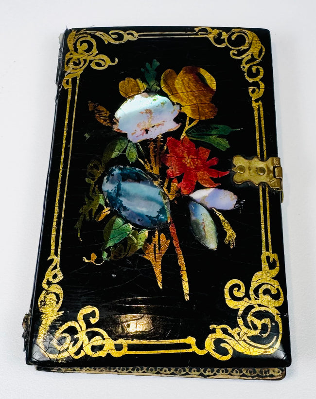 Antique black lacquer card case with colorful floral inlay, gilt corner scrollwork, and brass closure