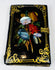 Antique black lacquer card case with colorful floral inlay, gilt corner scrollwork, and brass closure