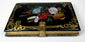 Victorian papier-mâché calling card case highlighting brass clasp, gilt ornament, and lacquered construction