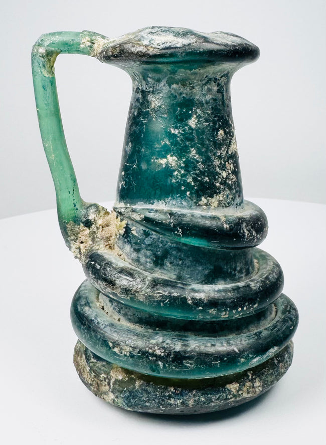 Ancient Roman blown-glass jug with folded rim and decorative raised glass trails