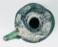 Top view of Late Roman glass jug showing circular mouth, flared rim, applied handle, and blue-green glass