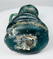 Underside of Late Roman blown-glass jug showing pontil scar, mineral deposits, and ancient glass weathering