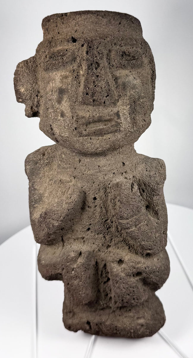 Ancient Mezcala-style stone effigy with geometric head, elongated nose, and compact seated form