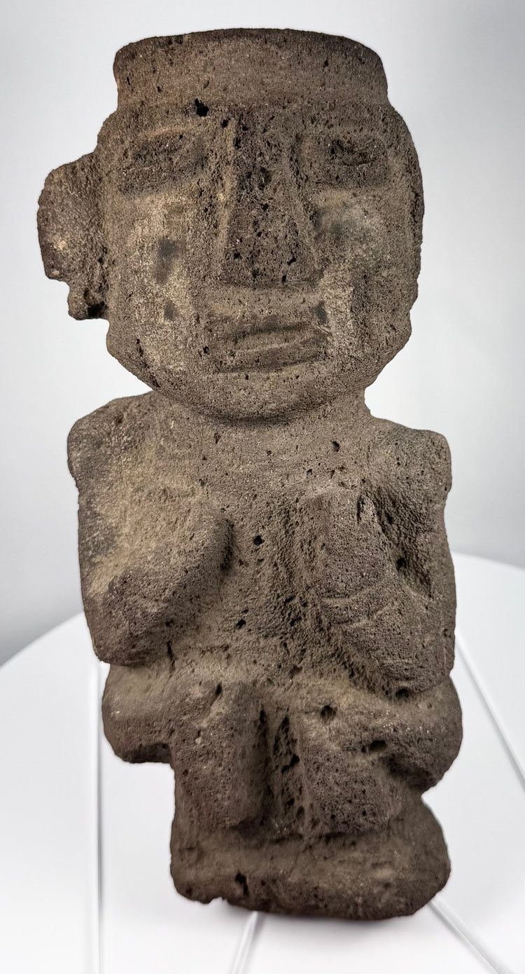 Ancient Mezcala-style stone effigy with geometric head, elongated nose, and compact seated form