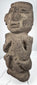 Pre-Columbian volcanic stone figure with recessed eyes, prominent brow, and stylized facial features
