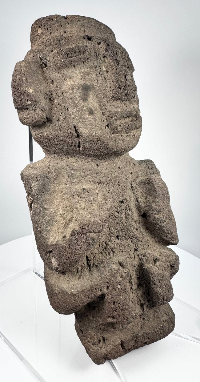 Ancient Mexican stone sculpture with projecting nose, lateral ear forms, and compact body