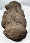 Pre-Columbian volcanic stone effigy with stylized face, folded arms, and seated posture