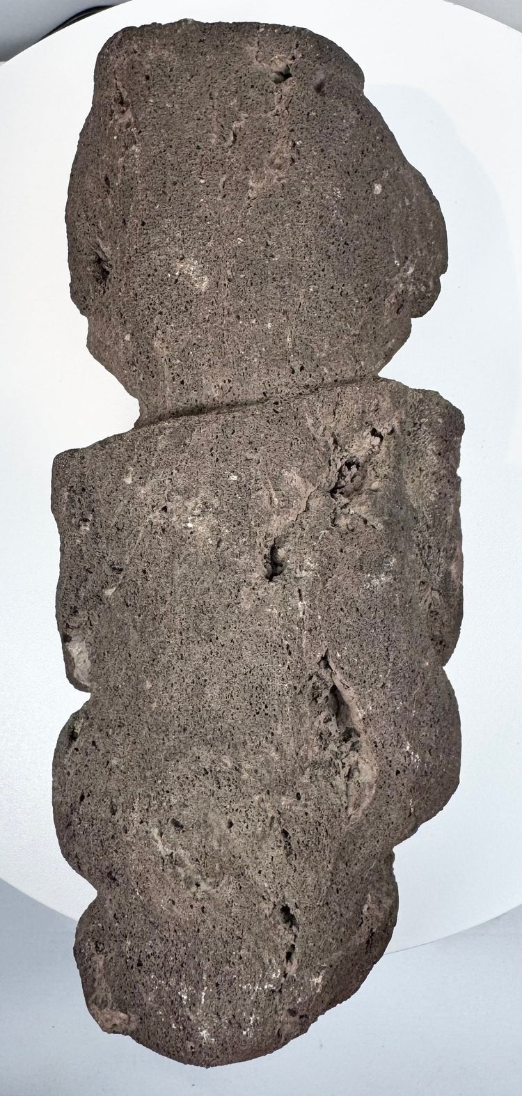 Back view of Pre-Columbian Guerrero stone figure showing flattened reverse and natural volcanic stone texture