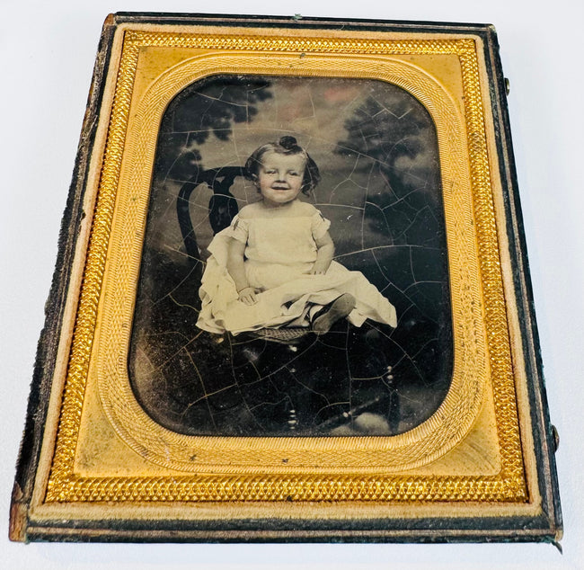 Mid-19th-century cased portrait of a young child seated in formal clothing within a gilt decorative frame