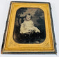 Mid-19th-century cased portrait of a young child seated in formal clothing within a gilt decorative frame