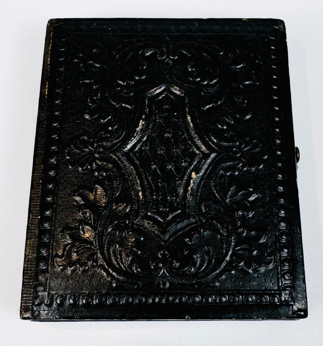 Antique photographic case with deeply embossed decorative exterior and age-related surface wear