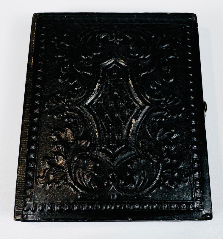Antique photographic case with deeply embossed decorative exterior and age-related surface wear