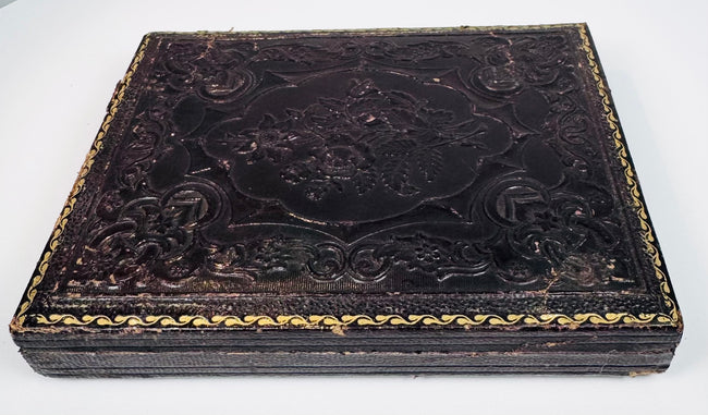 Victorian ambrotype case showing dark embossed floral exterior and age-related surface wear