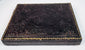 Victorian ambrotype case showing dark embossed floral exterior and age-related surface wear