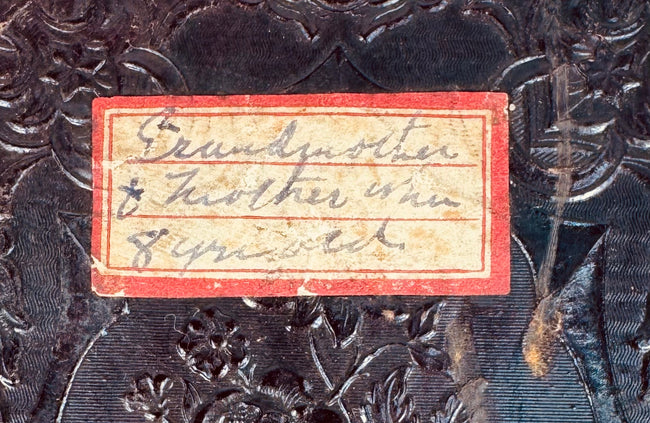 Handwritten family identification label reading “Grandmother + mother when 8 years old” on the Victorian photograph case