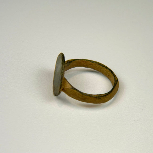 Ancient Roman finger ring displaying incised vertical lines across the bezel and centuries-old green patina