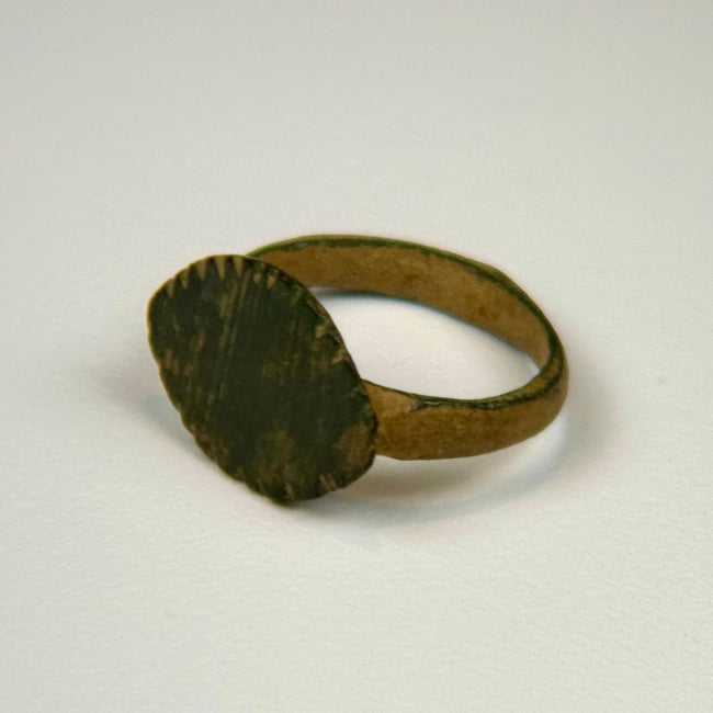 Imperial Roman bronze finger ring featuring an oval engraved bezel and natural green archaeological patina