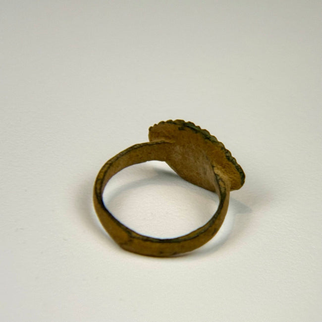 Roman bronze jewelry ring with linear bezel decoration, exposed metal highlights, and green burial patina