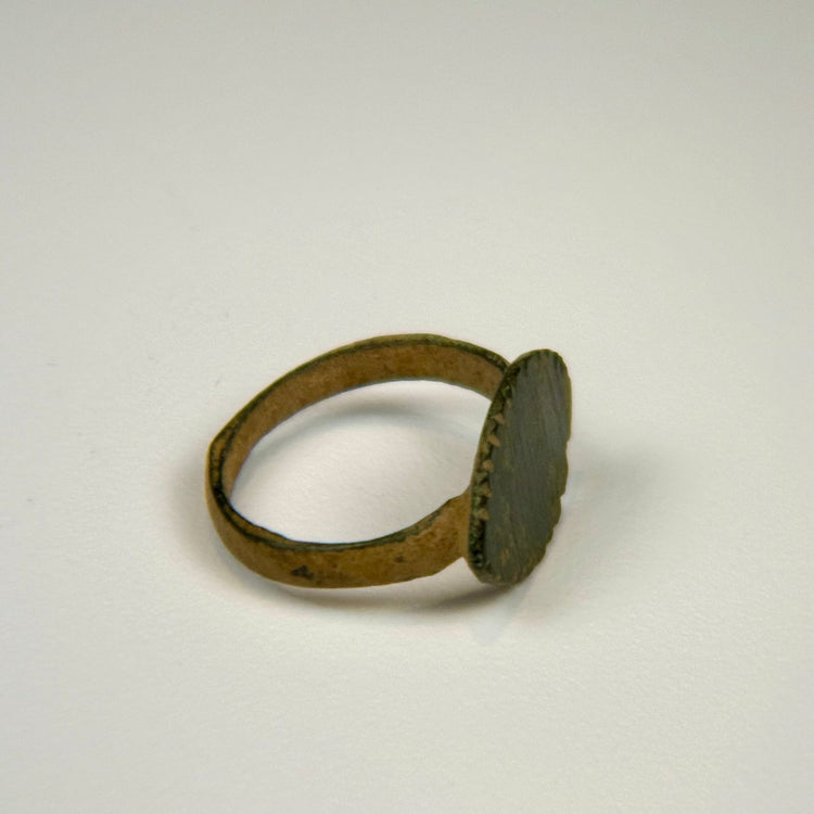 Imperial Roman bronze finger ring showing natural pitting, mineral deposits, and a well-defined bezel design