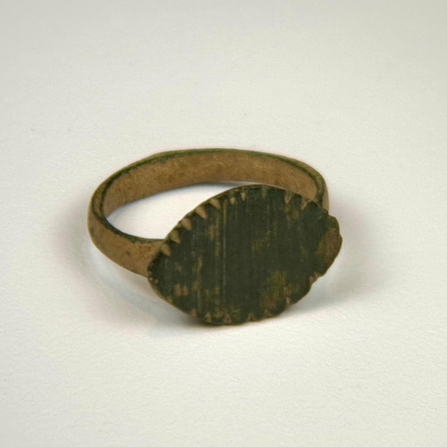 Ancient Roman bronze ring with raised oval bezel and incised vertical linear decoration, circa 100–300 CE