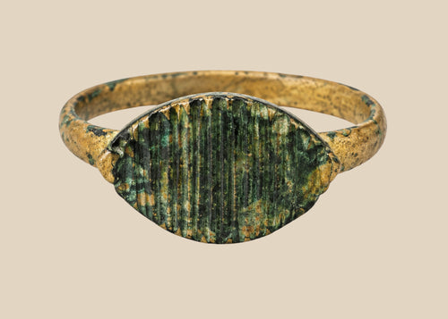 Imperial Roman bronze ring, circa 2nd–4th century AD, featuring incised linear decoration across its bezel; aged patina with green oxidation and surface wear from centuries of burial, historically used as both personal adornment and symbolic status marker within Roman society.