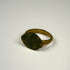 Roman bronze ring with prominent oval bezel, weathered surface, and traces of earthen encrustation