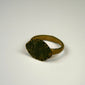 Roman bronze ring with prominent oval bezel, weathered surface, and traces of earthen encrustation