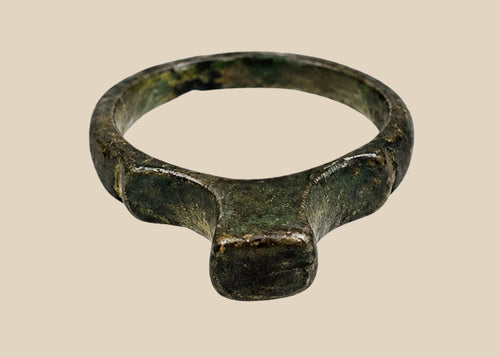 Authentic Roman bronze signet ring, circa 100–300 CE, with rounded band and flat bezel once engraved for sealing documents. Worn smooth from centuries of use, with deep green-black patina and earthen encrustations, a tangible relic of Roman identity.