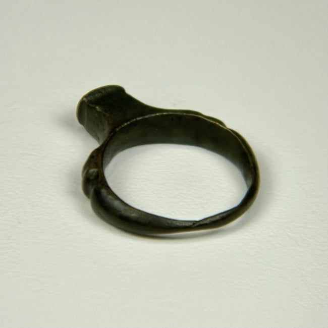 Roman bronze signet-style ring with intact rounded band and dark archaeological patination