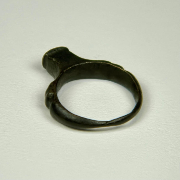 Roman bronze signet-style ring with intact rounded band and dark archaeological patination