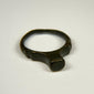 Ancient Roman bronze signet ring with broad flat bezel and deep green-black patina, circa 100–300 CE