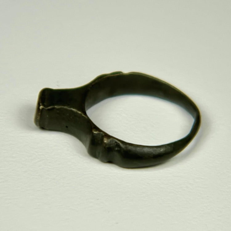 Roman bronze signet ring dating circa 100–300 CE with worn bezel and natural green-black patina
