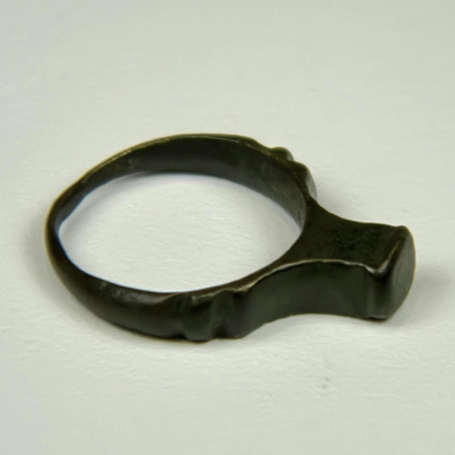 Roman period bronze finger ring featuring a wide flat bezel and centuries-old surface wear