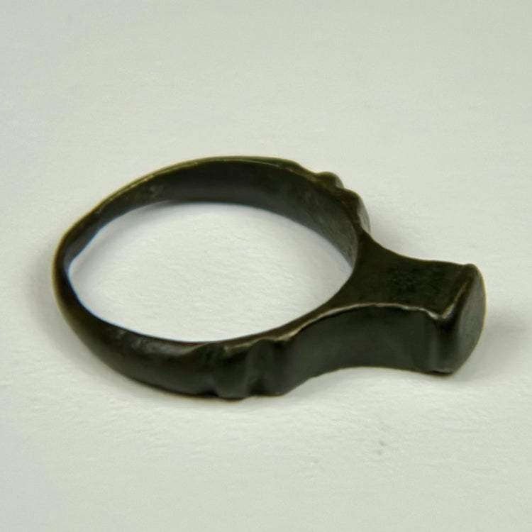 Roman period bronze finger ring featuring a wide flat bezel and centuries-old surface wear