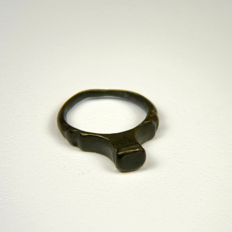 Imperial Roman bronze finger ring featuring a smooth worn bezel and rounded cast band