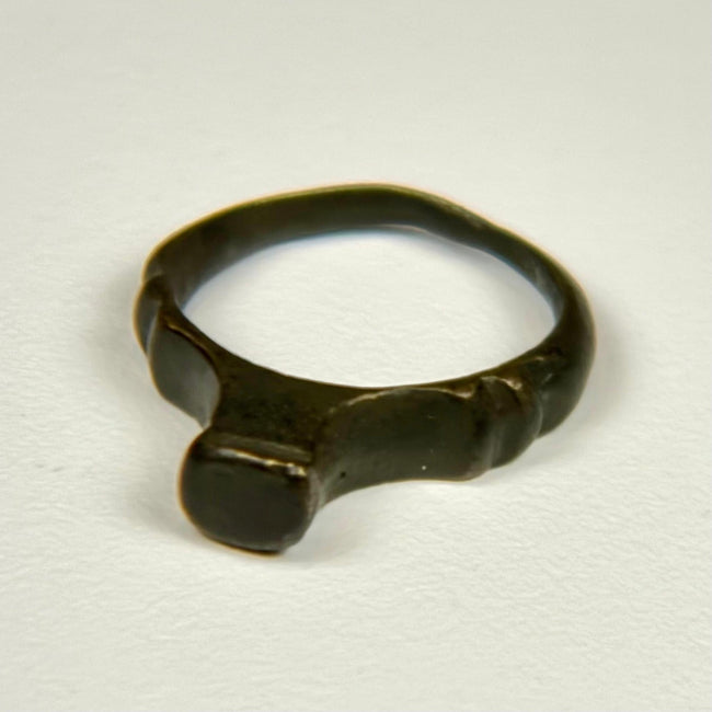 Ancient Roman signet ring with flat raised bezel, archaeological patina, and light earthen encrustation