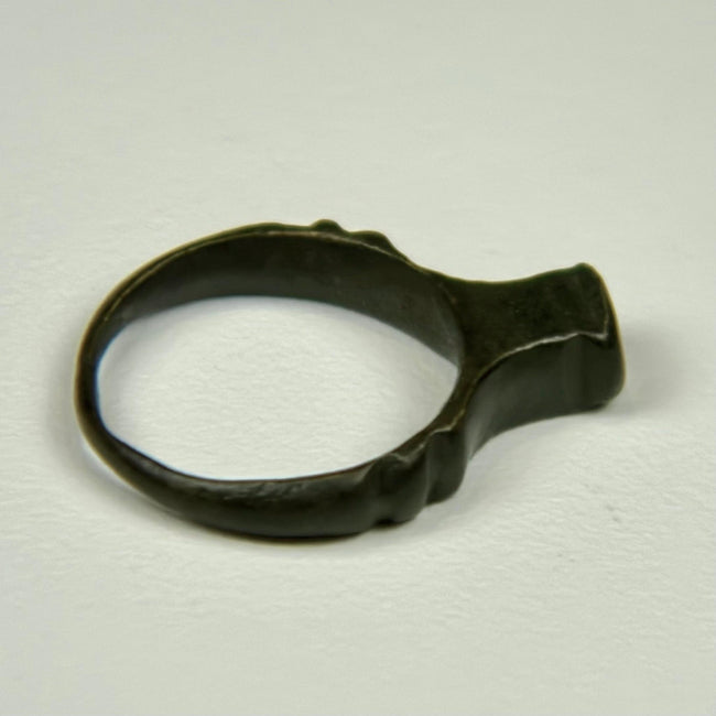 Ancient bronze signet ring from the Roman Empire with weathered bezel and light mineral deposits