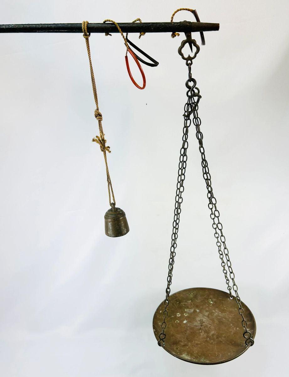 Antique Indian steelyard balance scale, circa 18th–19th century, with forged iron beam, engraved calibration notches, bronze hanging pan, and original cast bronze weight with woven cord. Traditional Mughal/Colonial trade tool with rich aged patina.