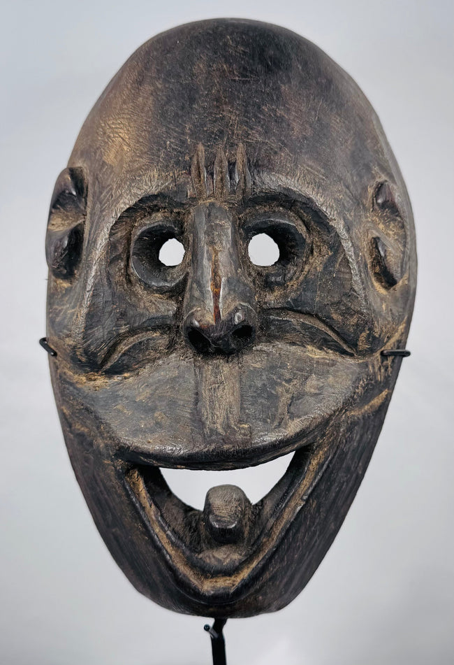 West Timor ceremonial mask hand-carved from hardwood with expressive simian features and aged patina.