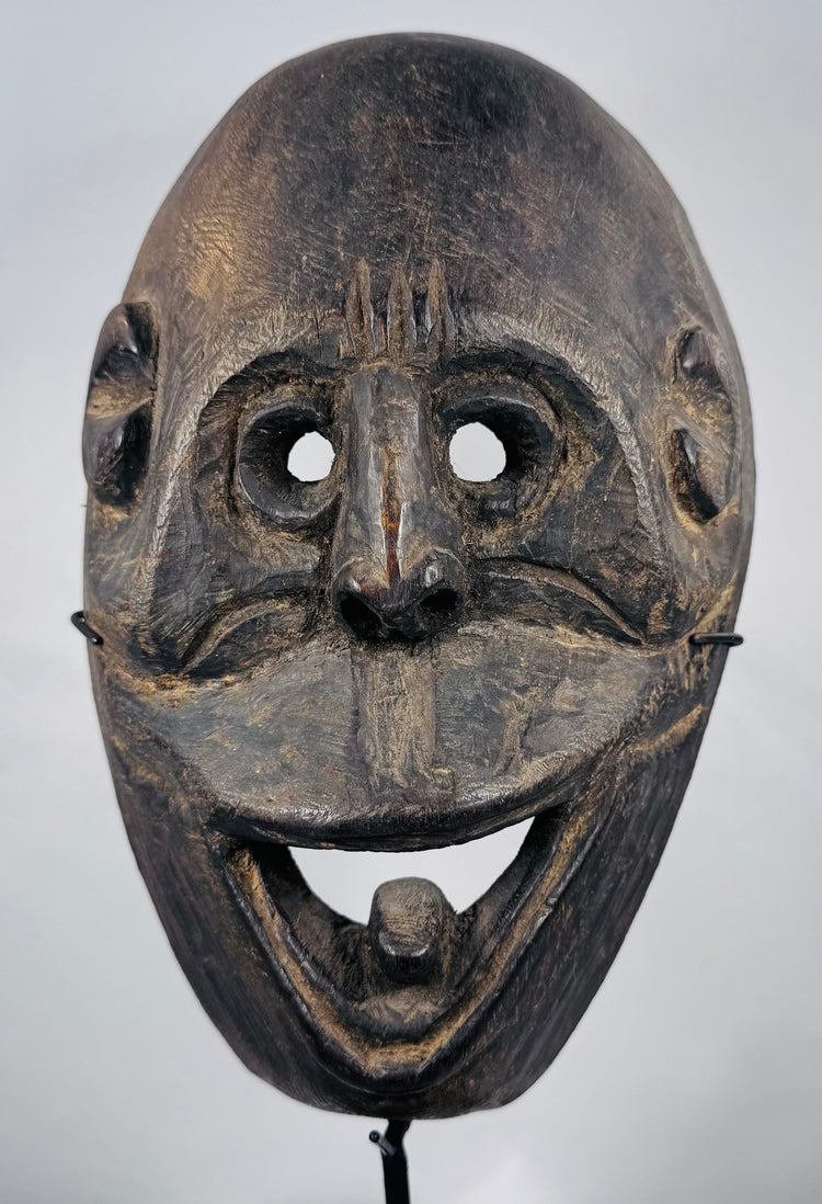 West Timor ceremonial mask hand-carved from hardwood with expressive simian features and aged patina.
