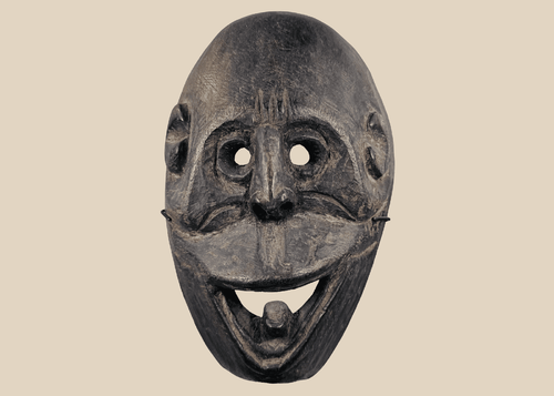 Carved wooden ritual mask from Fatuleu Village, West Timor, featuring large circular eyes and a protruding tongue, circa 1930.