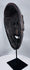 Traditional Timorese wooden mask with expressive monkey-like features and open mouth with protruding tongue.
