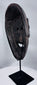 Traditional Timorese wooden mask with expressive monkey-like features and open mouth with protruding tongue.